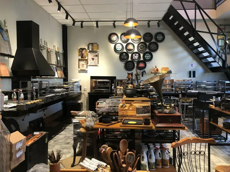 Showroom com coifa preta, churrasqueiras montadas e mesa de acessórios