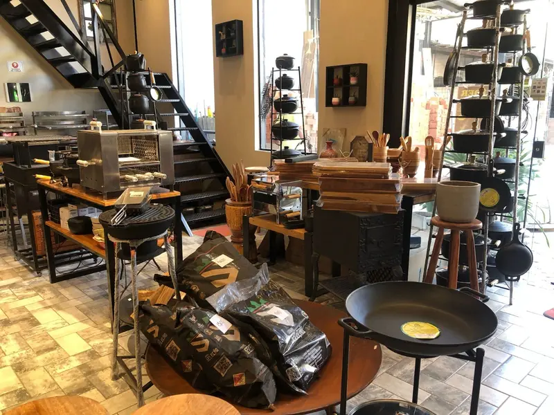 Showroom com mesas de acessórios, chapas de ferro e sacos de carvão