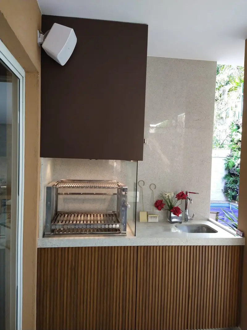 Churrasqueira compacta com grill de inox e frente de madeira ripada
