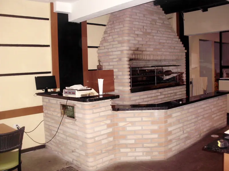 Parrilla de tijolinho claro embutida em balcão de atendimento