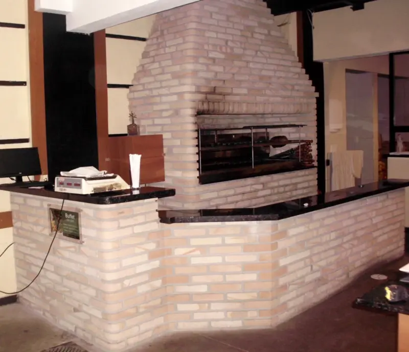 Parrilla de tijolinho claro embutida em balcão, vista lateral