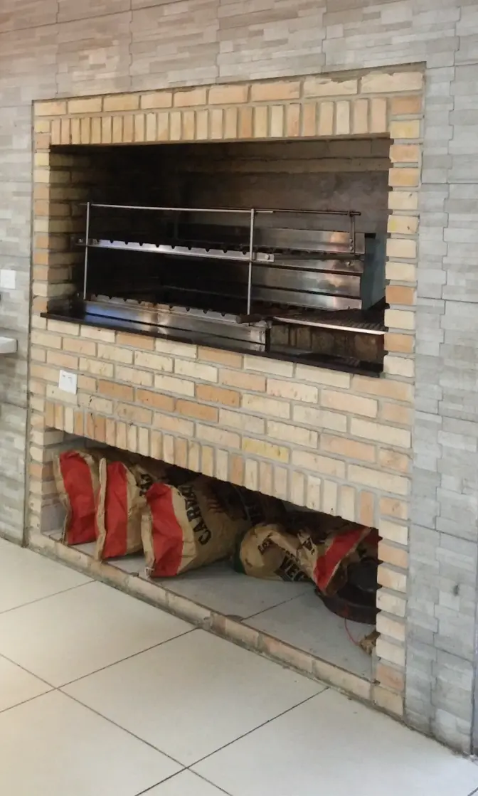 Churrasqueira embutida com grelha de inox e espaço pra carvão embaixo